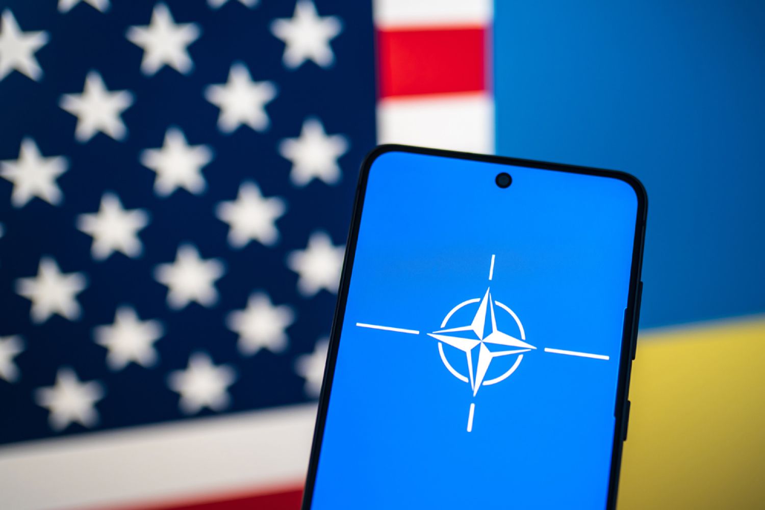 US-Flagge und ukrainische Flagge mit Handy und Nato-Symbol
