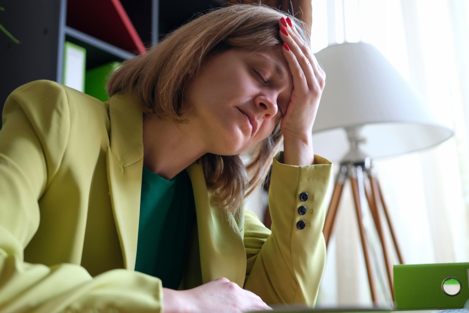 Frau hält sich Kopf müde