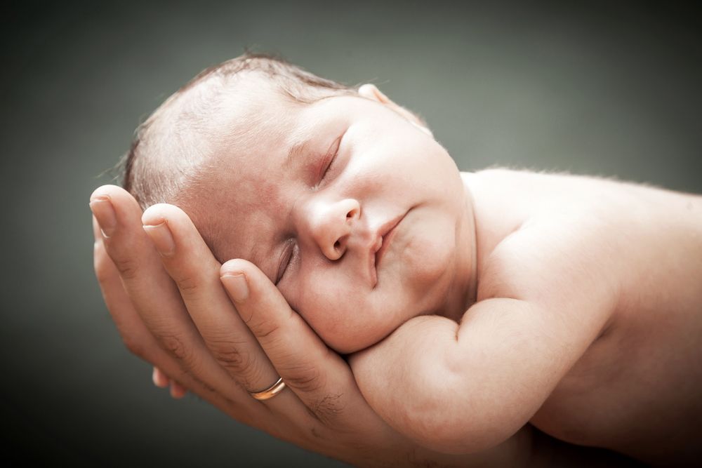 Baby in Hand eines Erwachsenen