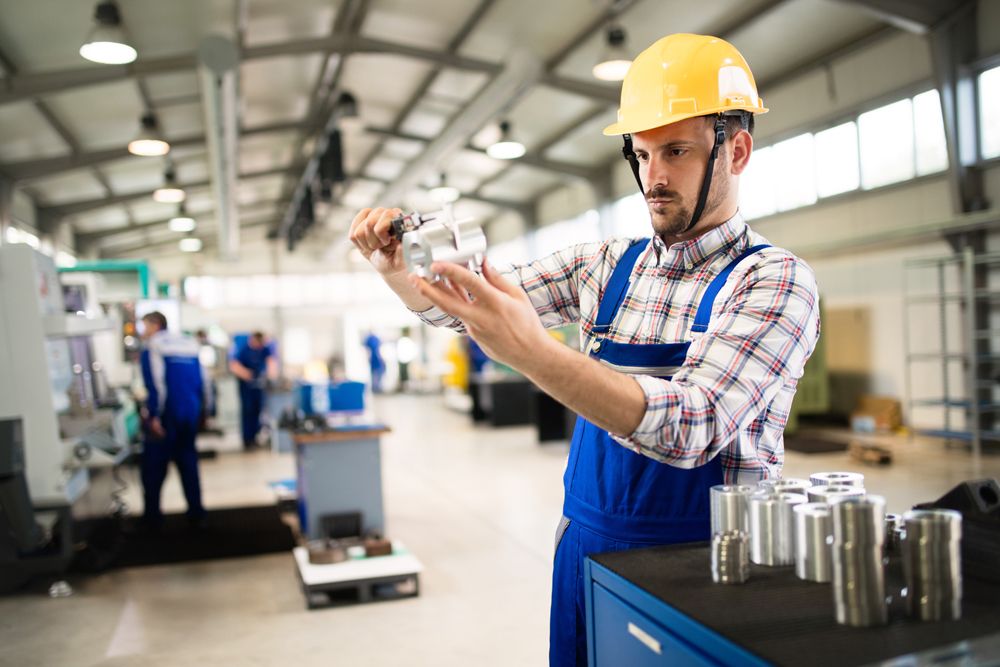 Arbeiter Fabrikhalle prüft Produkt