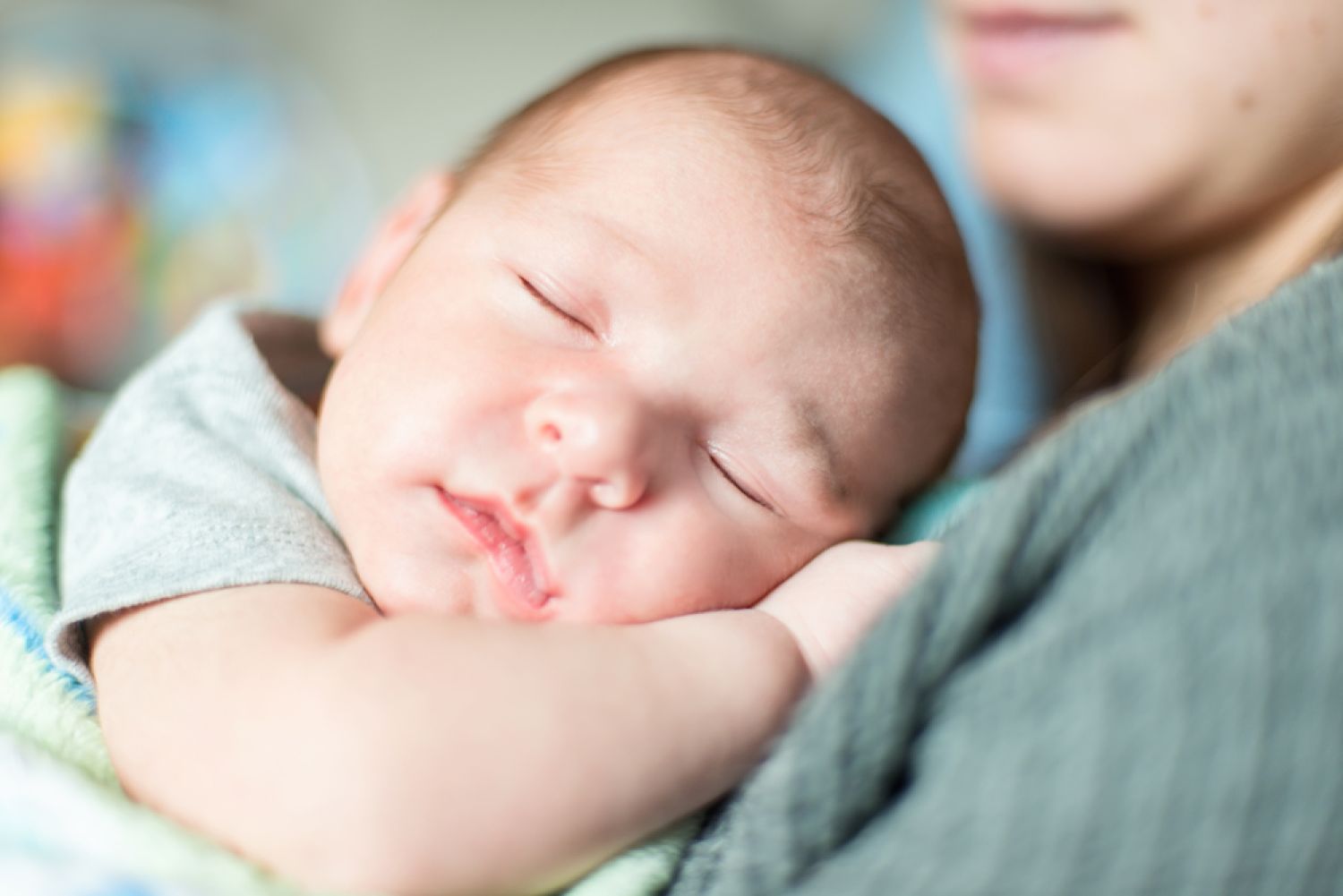 Baby schlafend im Arm seiner Mutter